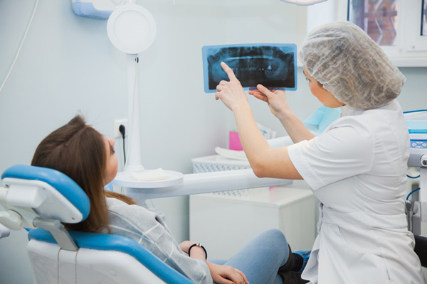 Dentista que muestra la radiografía del paciente en Easy Dental Implant and Carillas Center 